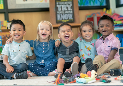 five preschool students laughing